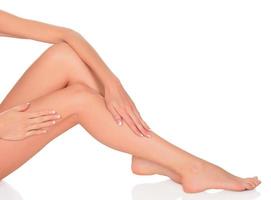 Smooth skin on female legs. White background, copyspace. photo