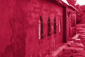 Beautiful red wall of the building. Red building with unusual Windows. photo