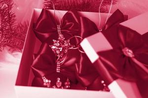 A Christmas gift decorated with a beautiful bow on a light background with a fir twig. Gifts, joy, surprise. Selective focus. the concept of Christmas and New Year photo