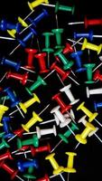 multicolored thumbtacks on a black background photo