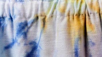 white cloth texture with yellow and blue patterns as background photo