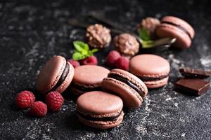 Macarons franceses de chocolate y frambuesa con relleno de ganache foto