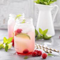 Cold green iced tea with lime and raspberry photo