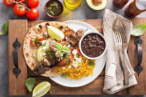 Beef kebab with rice, beans and fried plantains photo