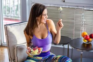 hermosa joven comiendo ensalada de verduras. dieta saludable. hermosa mujer sonriente comiendo ensalada vegetariana orgánica fresca. concepto de alimentación saludable, comida y estilo de vida. salud, belleza, concepto de dieta. foto