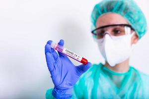 coronavirus covid 19 infected blood sample in sample tube in hand of scientist with biohazard protection clothing in coronavirus covid 19 reseach laboratory, coronavirus covid-19 vaccine research photo