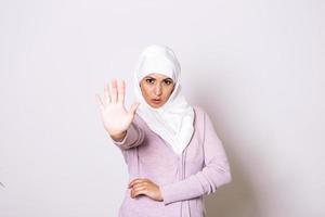 Stop Abuse. Frightened Afro Muslim Woman In Hijab Rejecting Something With Open Palm Hand Gesture, Standing Over Light Background photo