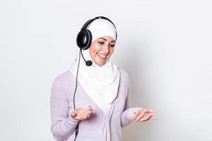mujer de negocios árabe del medio oriente con auriculares representante del cliente mujer de negocios con auriculares de teléfono ayudando y apoyando en línea con el cliente en un centro de llamadas moderno