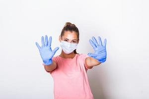 Portrait of young woman wearing face protective mask to prevent Coronavirus and anti-smog. Portrait of young woman wearing face mask showing stop sign with both hands. Covid-19 prevention concept photo