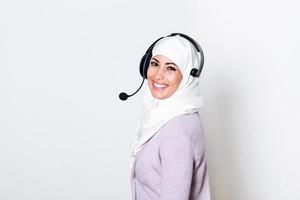 Arab middle eastern businesswoman with headphones customer representative business woman with phone headset helping and supporting online with customer in modern call centre photo