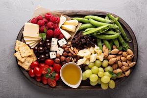 plato de queso con verduras y frutas frescas foto