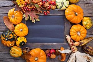 Variety of colorful decorative pumpkins around a chalkboard photo