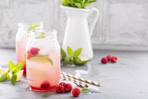 Cold green iced tea with lime and raspberry photo
