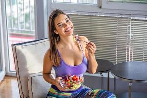 Beautiful Young Woman Eating Vegetable Salad . Healthy Diet. Beautiful Smiling Woman Eating Fresh Organic Vegetarian Salad. Healthy Eating, Food And Lifestyle Concept. Health, Beauty, Dieting Concept. photo