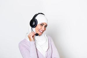 Young muslim female with hijab scarf customer representative business woman with phone headset helping and supporting online with customer in modern call centre photo