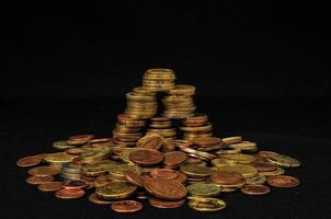 Pile of coins on black background photo