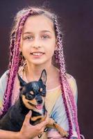 A teenage girl with a dog in her arms. The little girl had a pet chihuahua. photo