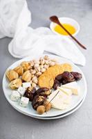 Cheese plate with crackers, dates and nuts photo