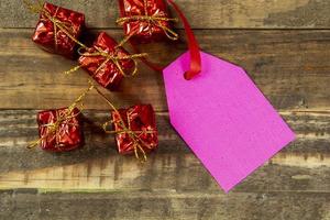 elementos decorativos de navidad junto a la tarjeta con cinta roja y espacio para escribir foto