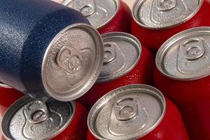 Cold red soda cans with a blue one for conceptual use photo