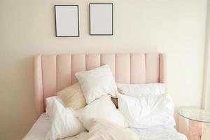 interior cálido y acogedor del espacio de la habitación con cama rosa, marco de póster simulado. acogedora decoración del hogar. foto