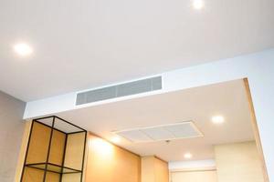 Ceiling mounted cassette type air conditioner and modern lamp light on white ceiling. duct air conditioner for home or office photo