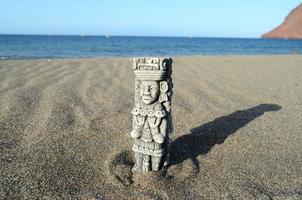 antigua estatua maya en la playa de arena foto