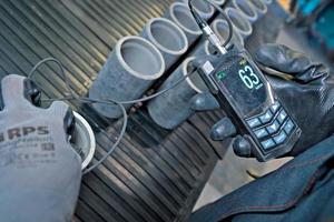 worker measures the thickness of the couplings of pumping oil pipes. photo