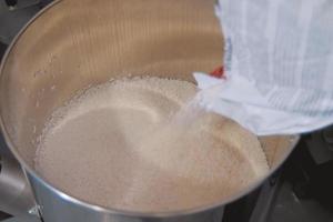 Pouring polymer granules into steel tank. Making explosives. photo