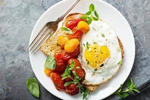 Multigrain toast with fried egg and roasted tomatoes photo