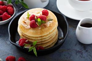 Stack of fluffy buttermilk pancakes with raspberry and coconut photo