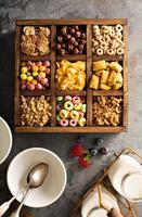Variety of cold cereals in a wooden box overhead photo