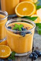 Orange and mango smoothie with granola photo