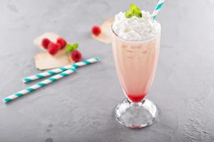 Iced milkshake with raspberry syrup and whipped cream photo