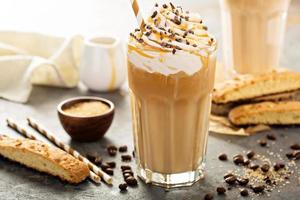 café con leche con caramelo helado en un vaso alto foto