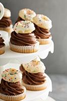 Cupcakes with chocolate frosting and little donuts photo