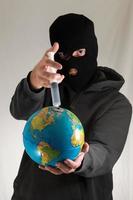 Masked man with syringe on a globe photo