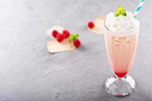 Iced milkshake with raspberry syrup and whipped cream photo