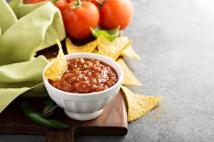 Red tomato spicy salsa with chips photo