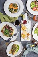 Big dinner table overhead view with steak and fish photo