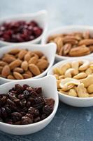 Variety of nuts and dried fruits in small bowls photo