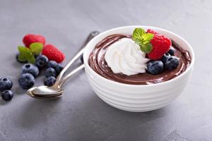 Chocolate pudding with whipped cream and berries photo