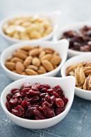 Variety of nuts and dried fruits in small bowls photo