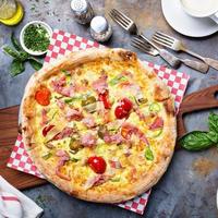 Breakfast pizza with scrambled egg, ham and tomatoes photo