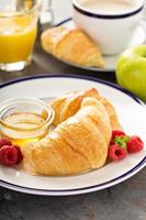 Freshly baked croissants with honey and jam photo