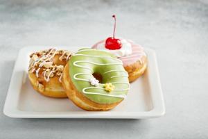 Assorted glazed fried donuts on a plate photo