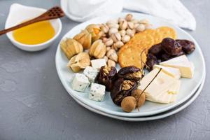 Cheese plate with crackers, dates and nuts photo