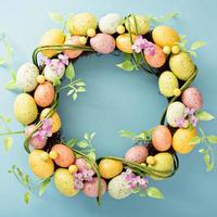 Easter eggs wreath on light blue background photo