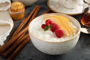 Rice pudding with raspberries and pears for breakfast photo