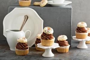 Cupcakes with chocolate frosting and little donuts photo